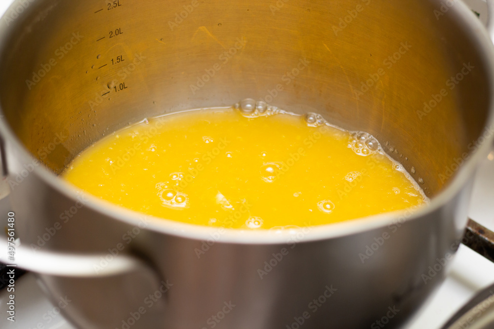 Orange jam boil in a saucepan. Bubbles in jam. Making jam at home. Orange confiture. Marmalade. Fruit jelly. Orange jam boil in a saucepan. Bubbles in jam. Making jam at home. Orange confiture. Marmalade. Fruit jelly.