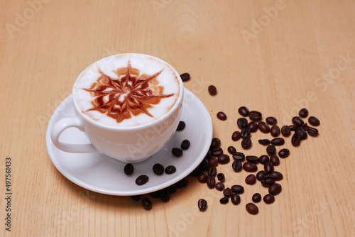 Hot latte coffee cup and beans isolated on wooden table