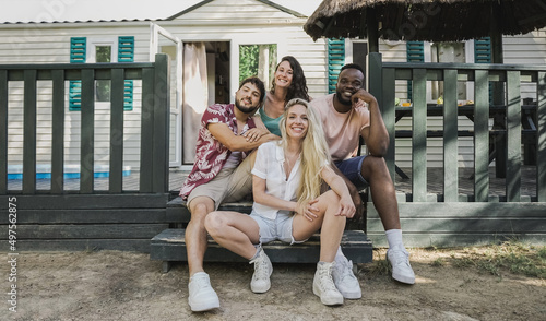 Multiracial young friends having fun outdoor at wooden house during summer vacations - Focus on center girl face © Vane Nunes