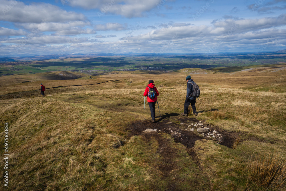 Hill walkerS descending from The Nine Standards Rigg on the Coast to Coast walk in the North Pennines near to Kirkby stephen