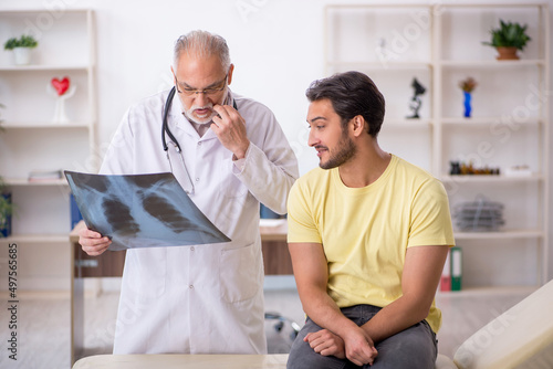Young male doctor visiting old male doctor radiologist