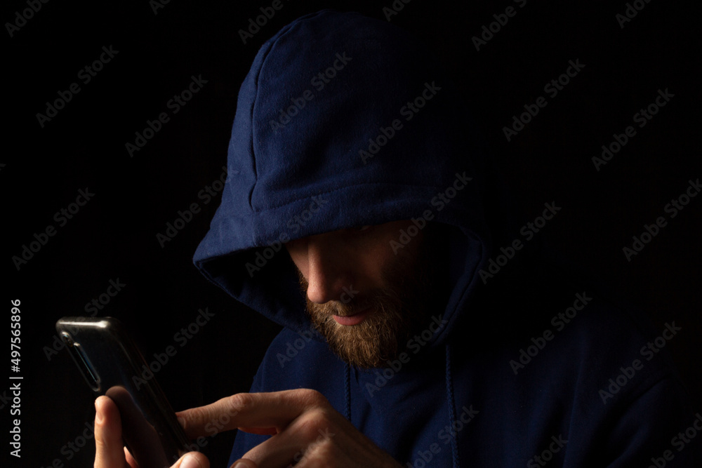 a man looks at a smartphone. writes a message on the phone in the dark a man looks at a smartphone. writes a message on the phone in the dark
