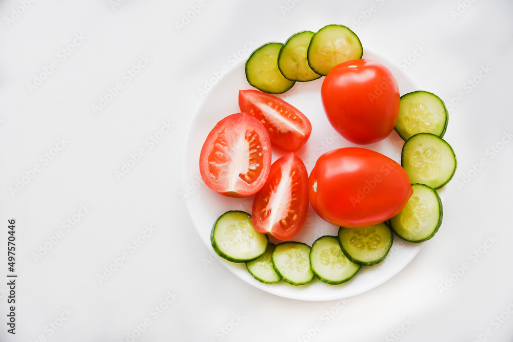Slicing vegetables on a white plate tomatoes and cucumbers Slicing vegetables on a white plate tomatoes and cucumbers