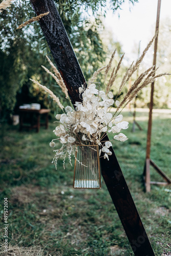 a pot of flowers hangs on a wedding arch in boho style wedding decorations in boho style preparation for the wedding ceremony