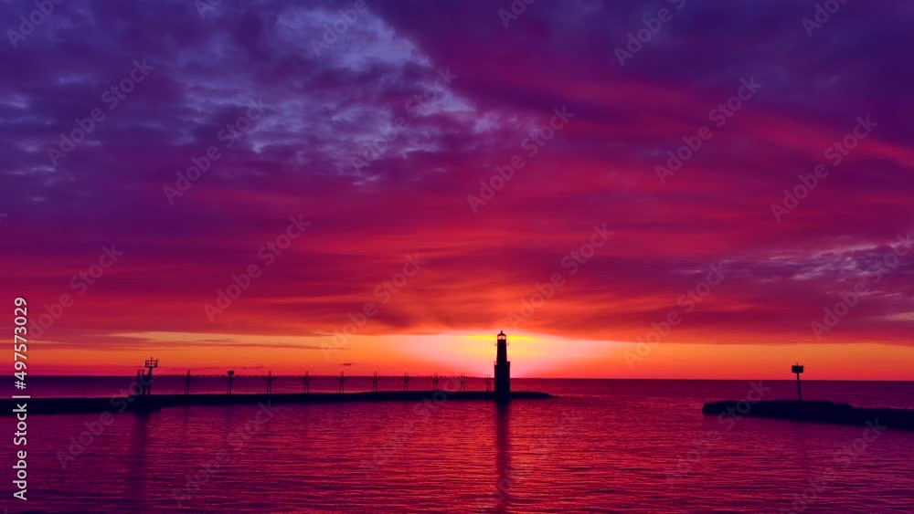 Incredible red sky at morning, over scenic Lake Michigan harbor and lighthouse, reflected in tranquil waters. Incredible red sky at morning, over scenic Lake Michigan harbor and lighthouse, reflected in tranquil waters.