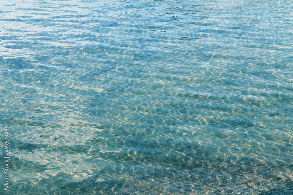 Abstract rippled clear water, rocky bottom defocus