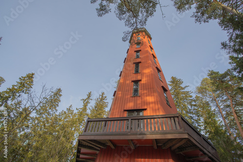 High wooden observation tower with an observation deck against the blue sky, view from the ground, Finland. The concept of nature exploration, observation deck, photo