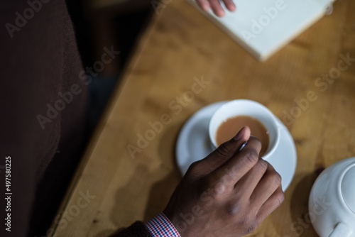 person stiring cup of tea