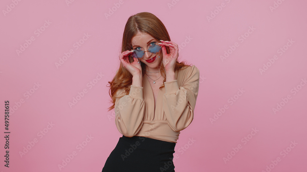 Sincere cool cheerful casual businesswoman girl in beige blouse wearing red sunglasses, charming smile. People emotions concept. Young lovely adult woman posing isolated on pink studio wall background