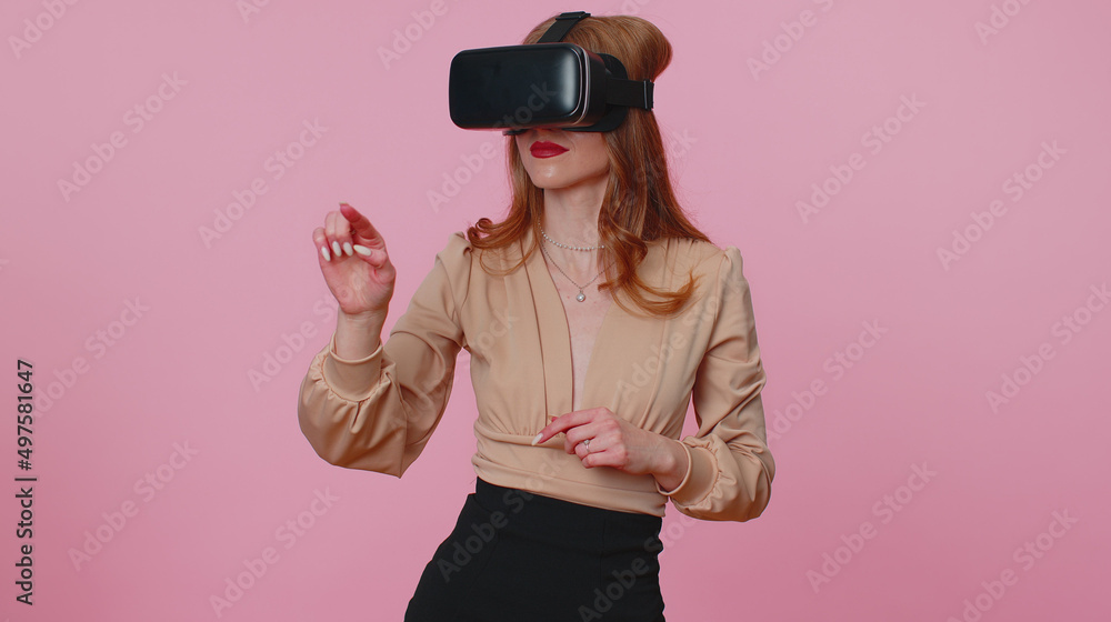 Businesswoman girl using virtual reality futuristic technology VR app headset helmet to play simulation 3D 360 video game, drawing. Young adult woman on pink studio background. People sincere emotions Businesswoman girl using virtual reality futuristic technology VR app headset helmet to play simulation 3D 360 video game, drawing. Young adult woman on pink studio background. People sincere emotions