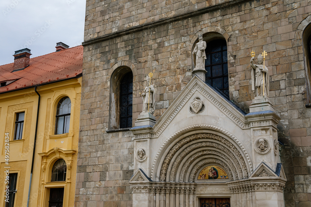 Fototapeta premium Tepla, Czech Republic, 7 August 2021: Premonstratensian Abbey and monastery, Romanesque church of the Annunciation with towers, gothic arched portal with stone carved statues of saints at summer day