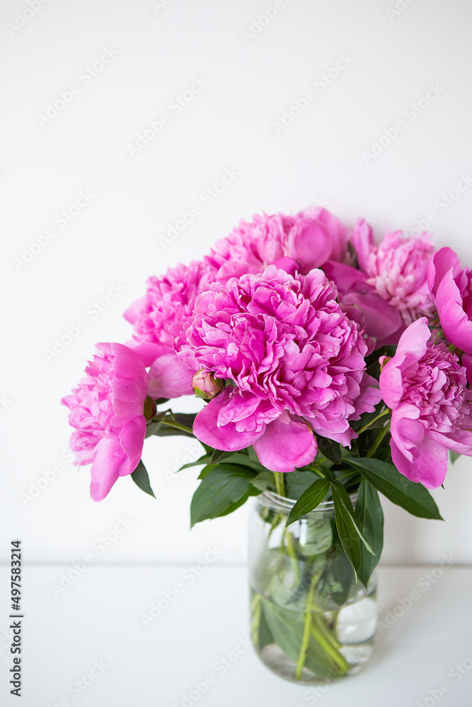 Beautiful bouquet of pink peony flowers in a vase on a white table. Flower surprise on March 8. Beautiful bouquet of pink peony flowers in a vase on a white table. Flower surprise on March 8.
