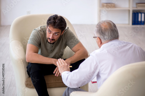 Young man visiting old psychologist