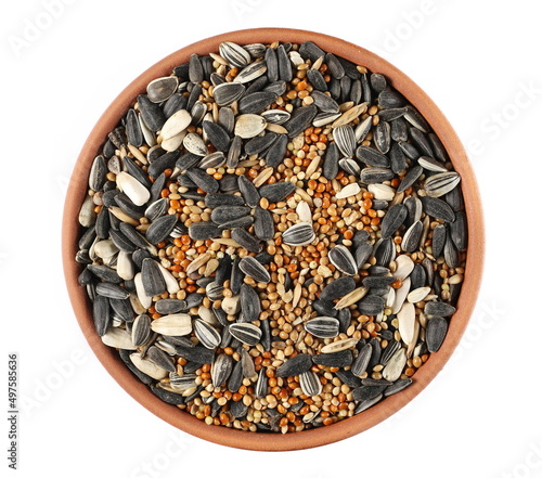 Mixed seeds millet, sunflower and oats pile for exotic birds in clay pot isolated on white, top view photo