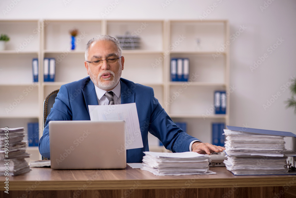 Old male employee working in the office Old male employee working in the office