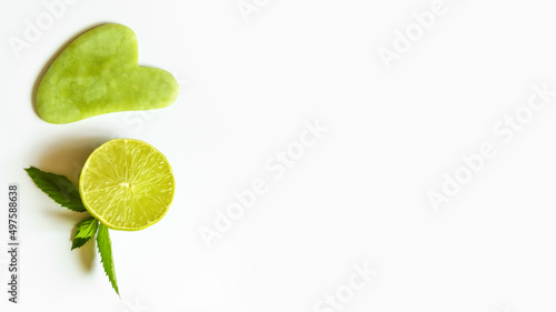 lime lemon green stone for face massage guasha on white background copy space