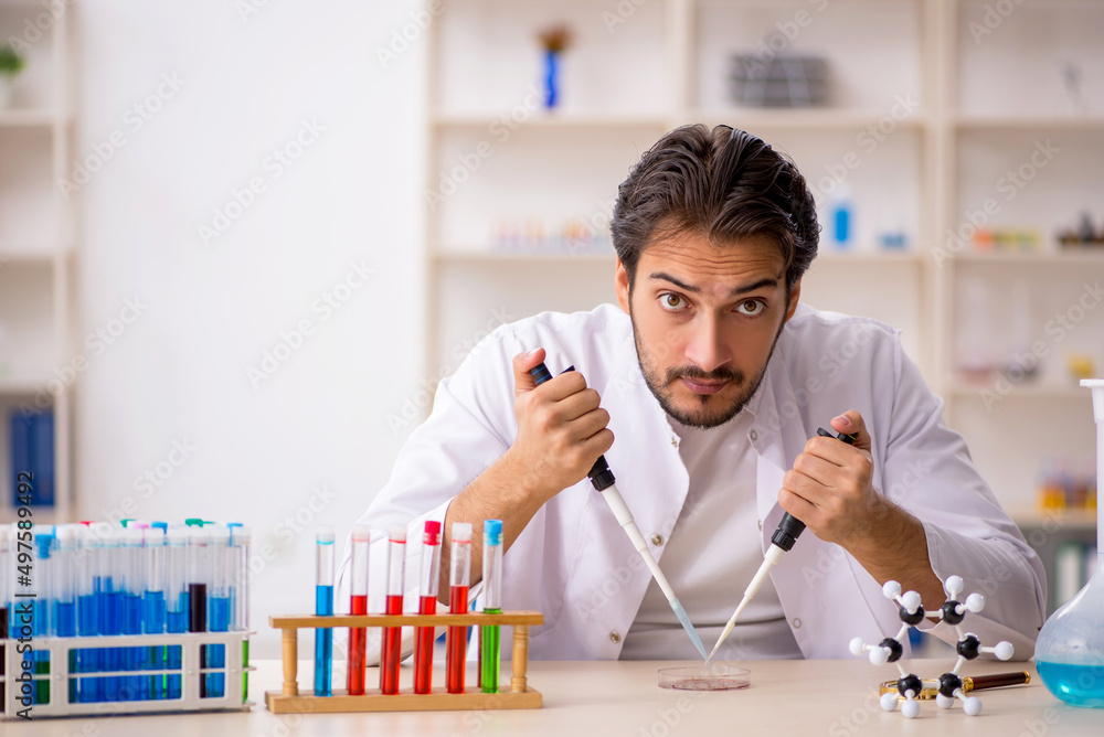 Young male chemist working at the lab Young male chemist working at the lab
