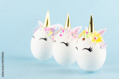 Easter unicorn eggs isolated on blue background. Happy easter banner. Kids activity inspiration. Greeting card or poster. Copy space for text