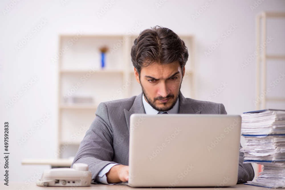 Young male employee and too much work in the office