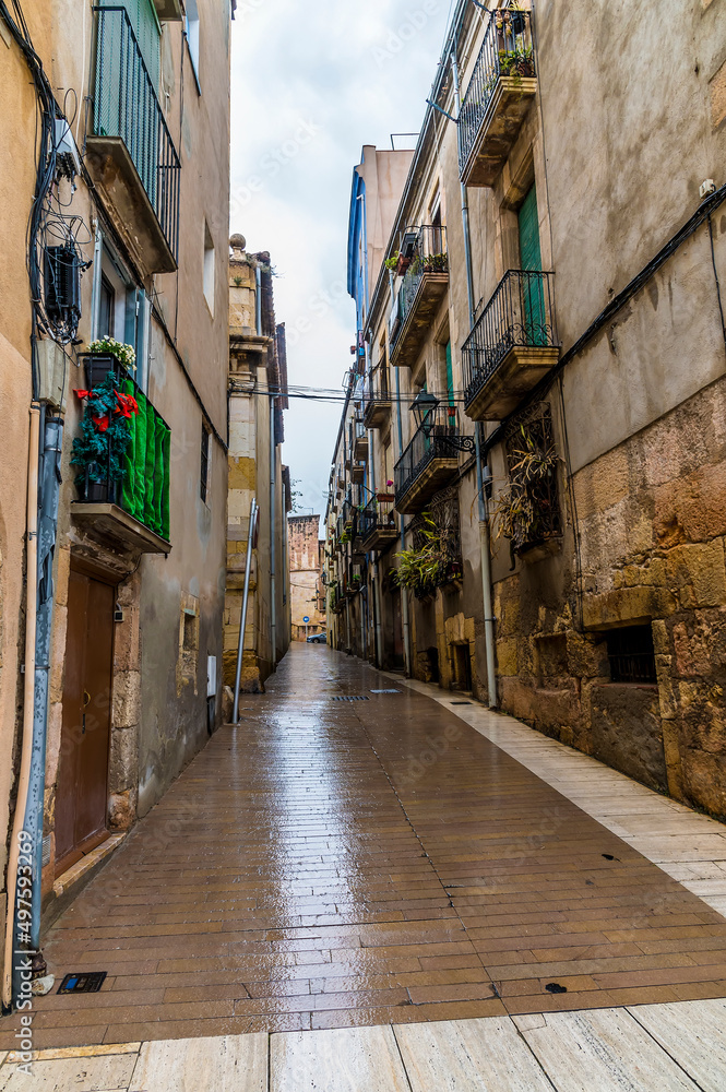 Fototapeta premium A view up a narrow street in the centre of the city of Tarragona on a spring day