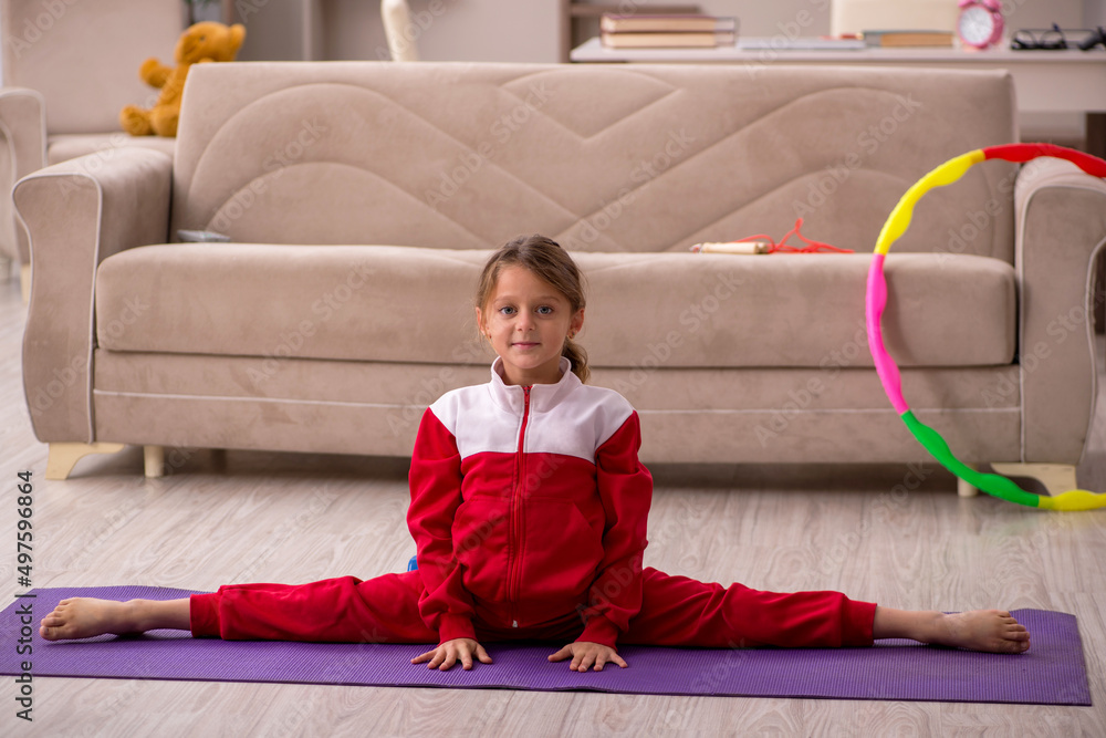Young little girl doing sport exercises at home Stock Photo | Adobe Stock