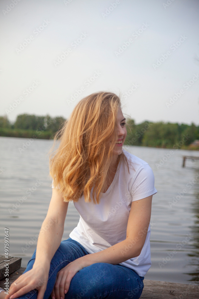 Fototapeta premium Beautiful blonde girl near the river.