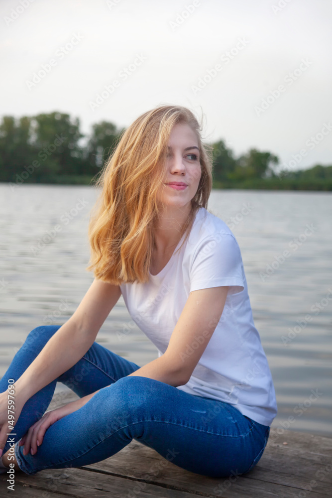 Beautiful blonde girl near the river.