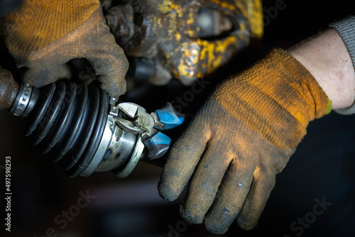 Obraz na płótnie installation of the drive shaft of the joint and half shaft in the engine gearbox, a metal clamp on the rubber boot. w salonie