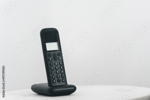 Modern wireless phone handset on black cordless station photo