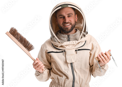 Male beekeeper in protective suit with supplies on white background photo