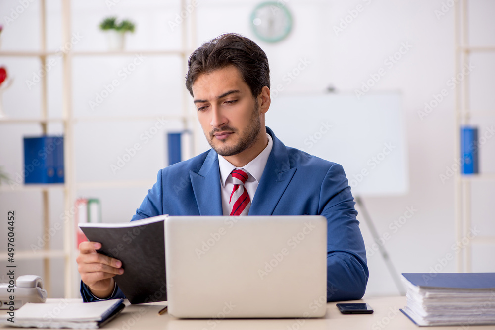 Young male employee working in the office Young male employee working in the office