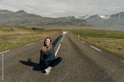 girl sitting on the road against the backdrop of Icelandic landscapes photo