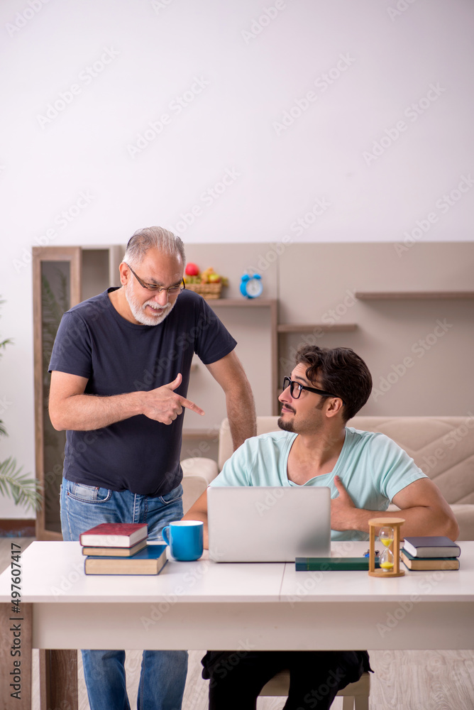 Young male student and his grandfather at home Young male student and his grandfather at home