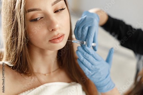 Young caucasian woman having lip injection at beauty center