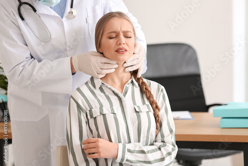 Doctor examining woman's ne...