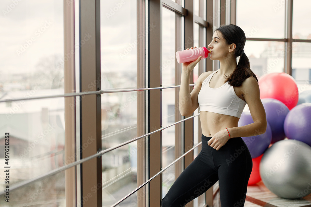Fitness girl working out at gym and drinking a water Fitness girl working out at gym and drinking a water