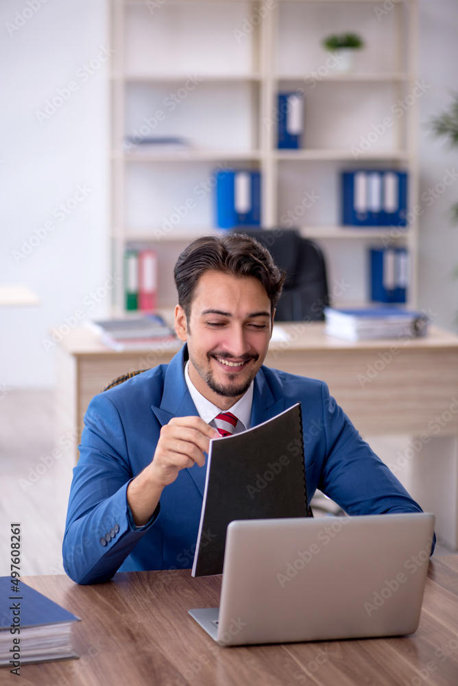 Young male employee working in the office Young male employee working in the office