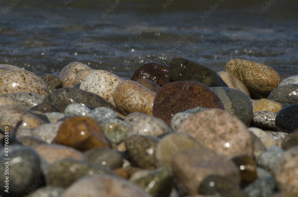 water beating on the colored stones on the shore of a lake water beating on the colored stones on the shore of a lake