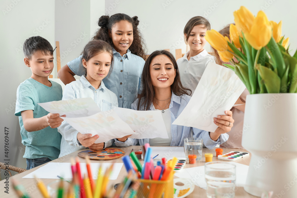 Cute children showing teacher their pictures painted during master-class in art Cute children showing teacher their pictures painted during master-class in art