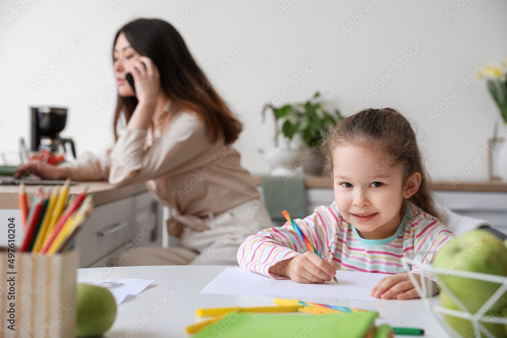 Little daughter with working mother at home Little daughter with working mother at home