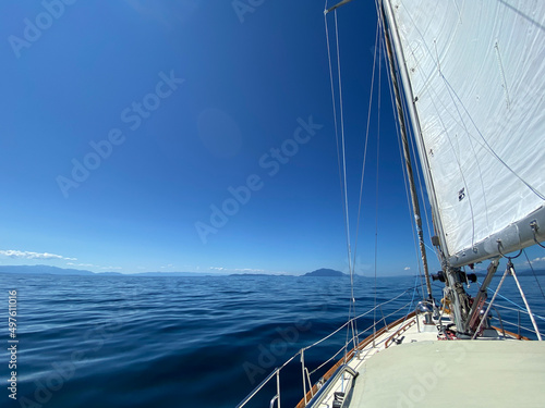 Fototapeta View of sailboat sailing along with sails up and tilted by the wind