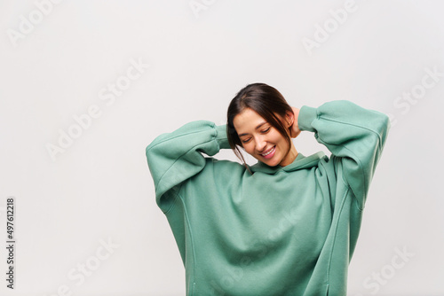 Happy carefree young brunette woman posing with her hands over her head and eyes closed over white studio background with copy space © Vadim Pastuh