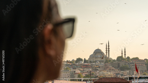 Woman with sunglasses observing the beautiful views of the city of Istanbul with the Bosphorus river and the Suleiman Mosque photo