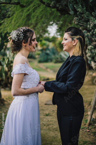 Vertical closeup shot of the two Caucasian females taking photos on their wedding day © Fran Martínez