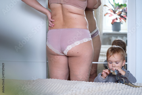Curvy Woman Getting Ready while daughter is playing  photo
