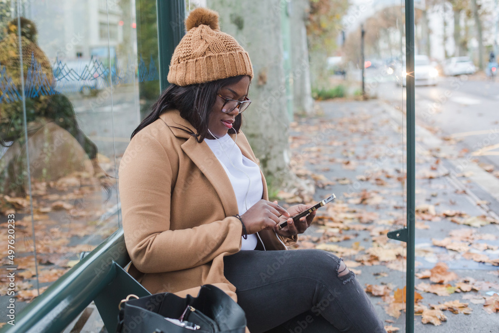 black woman using smartphone on bus stop, transport black woman using smartphone on bus stop, transport