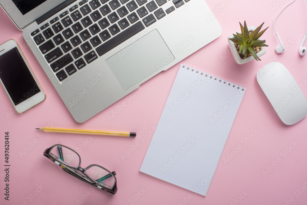Pink office desk with an empty laptop, computer keyboard and other stationery. Top view with copy space, flat lying. Pink office desk with an empty laptop, computer keyboard and other stationery. Top view with copy space, flat lying.