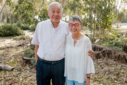 Loving senior Asian couple in eucalyptus grove photo