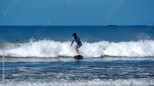 Man surfing off the beach in Tamarindo, Guanacaste, Costa Rica