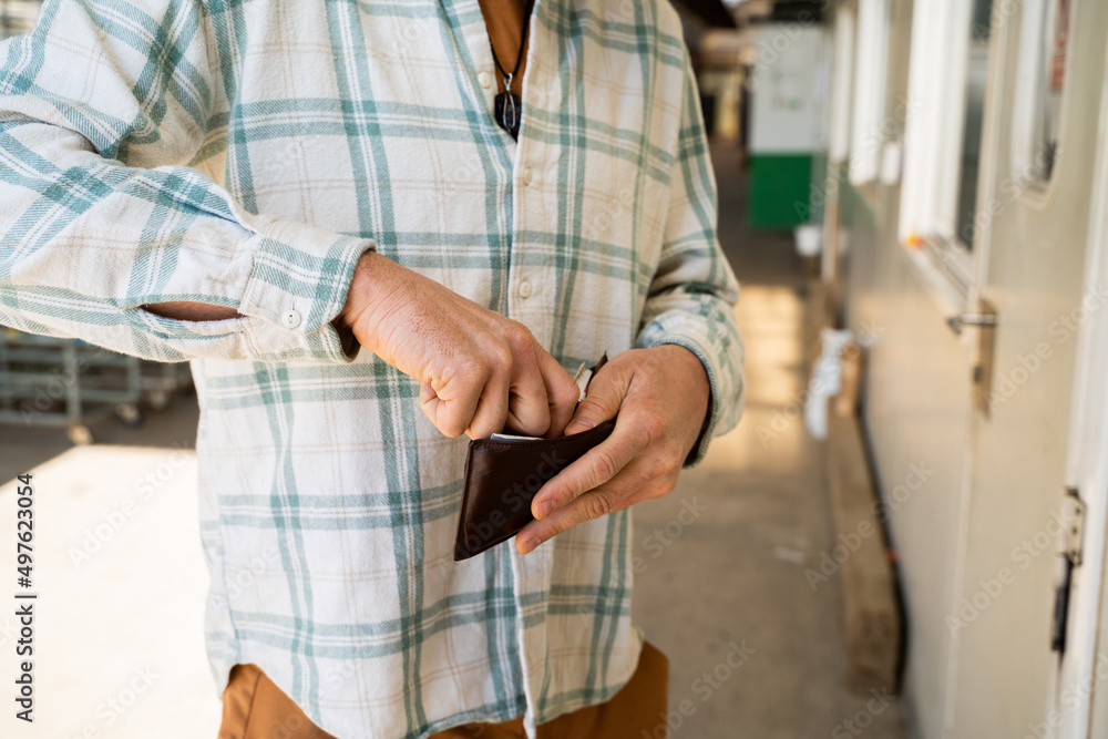 Close-up image of man paying with wallet cash Close-up image of man paying with wallet cash